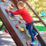 Cute little boy playing on the playground. Happy and healthy childhood. Kids outdoors playground.
