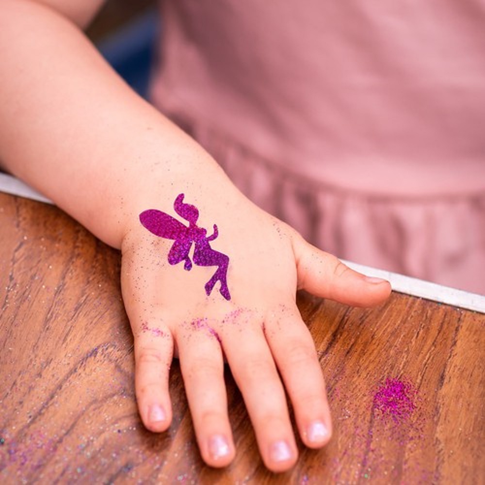 Shimmering sparkling glitter tattoo on a child’s hand at a birthday party